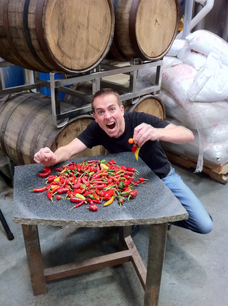 GK's Harvest of Chili Peppers Greg holding chili peppers in front of a pile of chili peppers